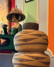 Schwarz-naturfarbener Art Basket in einem farbenfrohen Raum mit einer Skulptur