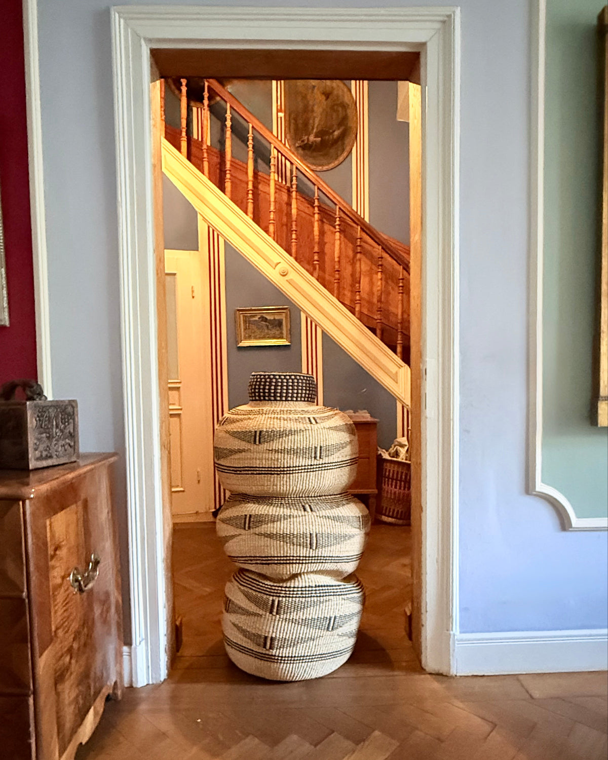 Kenkansia Art Basket, rund einen Meter hoch, im Flur neben einer Treppe