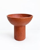A terracotta-colored paper pulp pedestal bowl with a textured, matte finish, set against a plain white background.