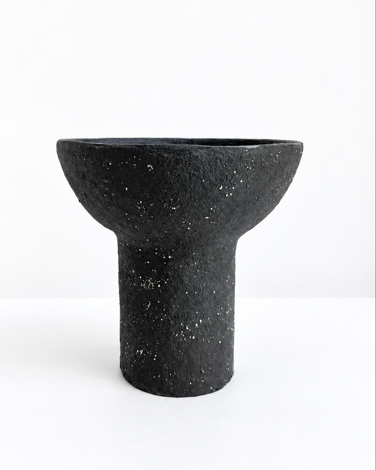 A black textured paper pulp bowl with a wide, shallow bowl-like top and a cylindrical pedestal base, shown on a clean white background.