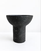 A black textured paper pulp bowl with a wide, shallow bowl-like top and a cylindrical pedestal base, shown on a clean white background.