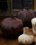 Textured vases on a wooden floor with a blurred background
