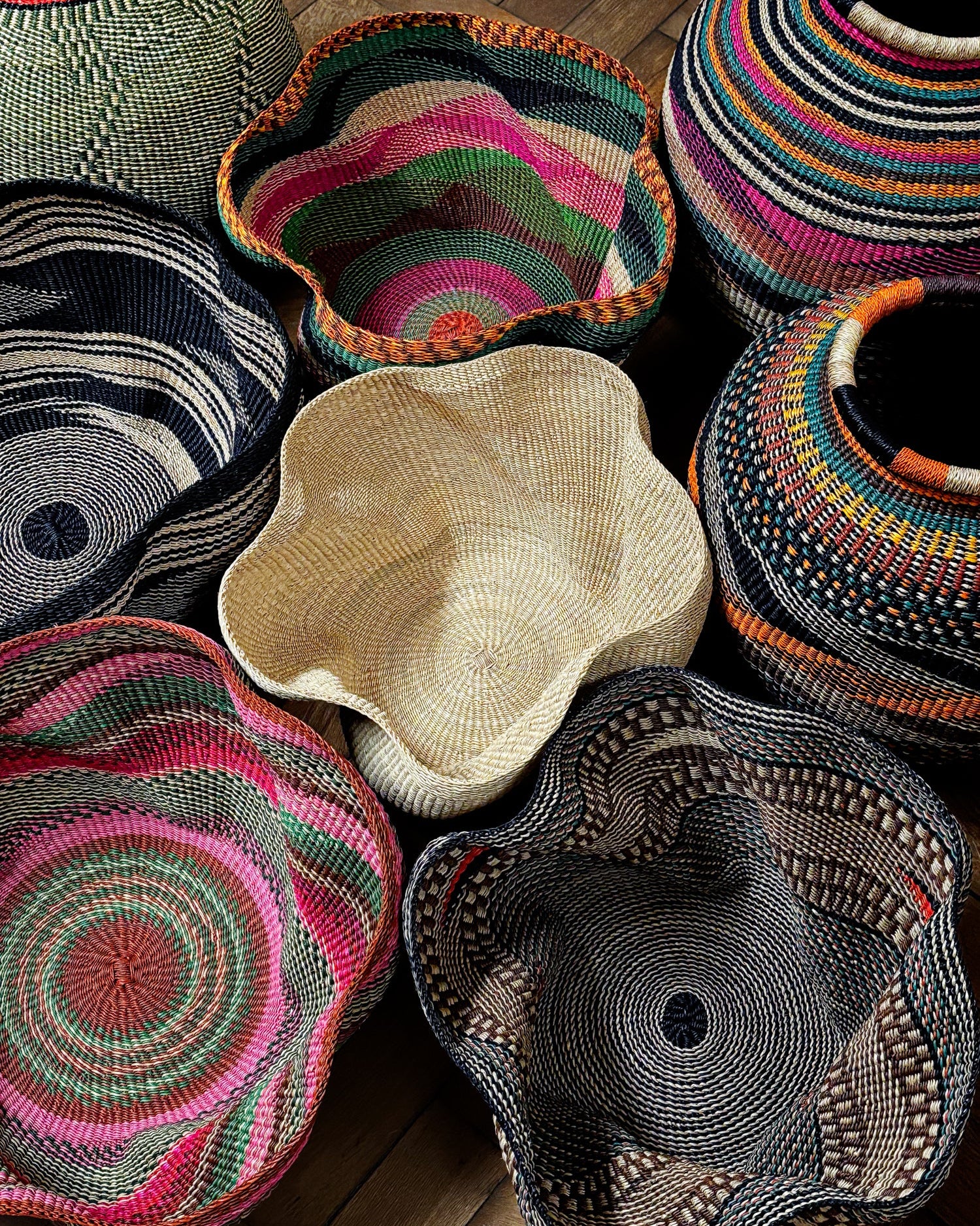 Collection of colorful woven baskets on a wooden surface